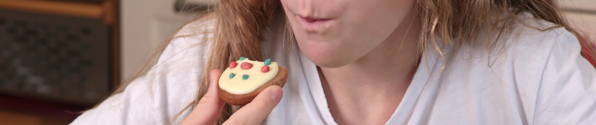 Das Mädchen isst einen Kuchen.